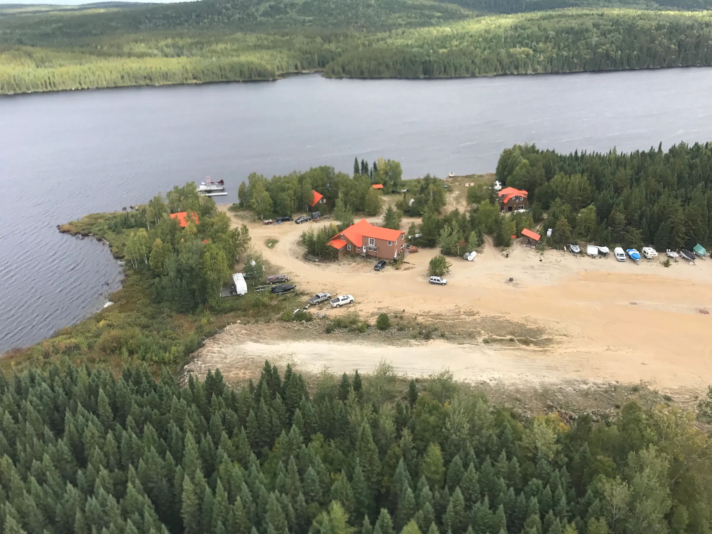 Vue aérienne de l'auberge et des chalets situés en bordure du lac.