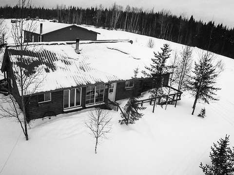 Vue aérienne de l'auberge recouverte de neige en hiver.