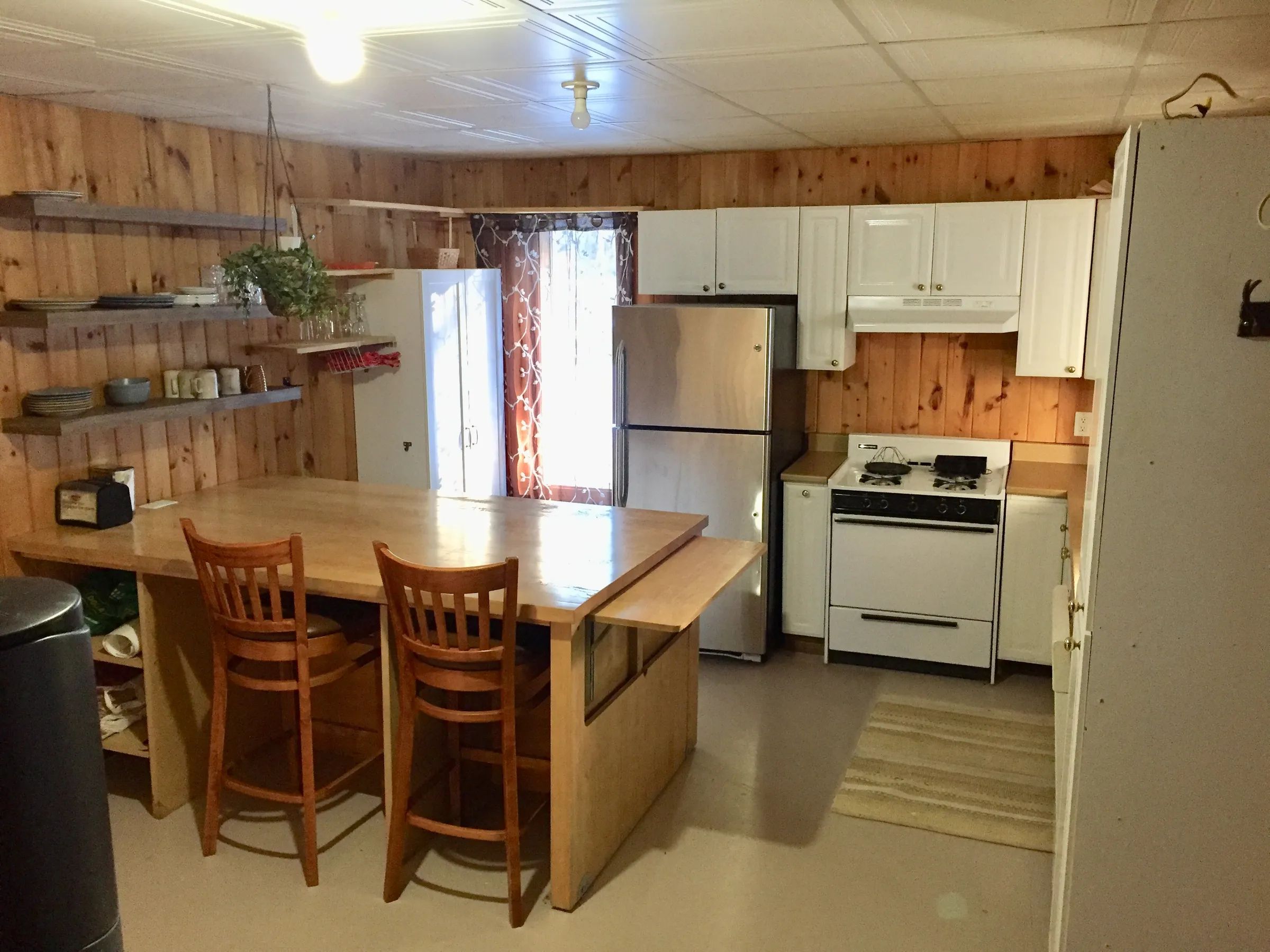 La cuisine équipée du chalet 4 dispose d'un comptoir-lunch en bois et d'appareils électroménagers.