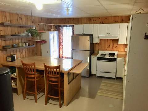 La cuisine équipée du chalet 4 dispose d'un comptoir-lunch en bois et d'appareils électroménagers.