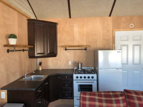 La cuisine équipée du chalet dispose d'un réfrigérateur, d'une cuisinière et d'un évier fonctionnel.