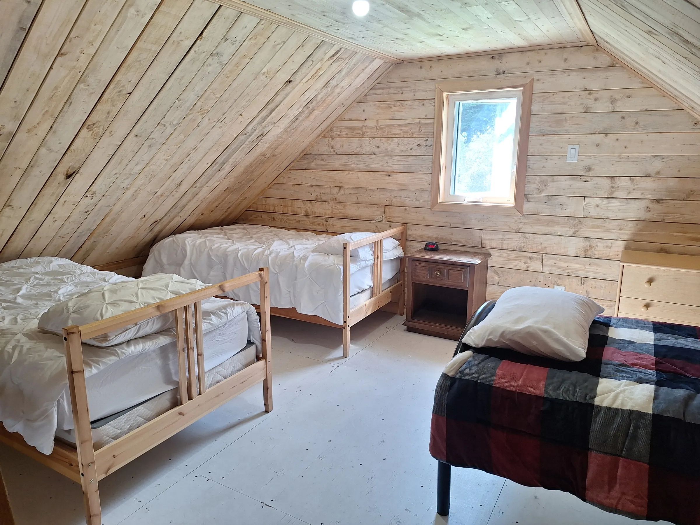 This bedroom under the roof of the Matalik chalet includes several wooden beds.