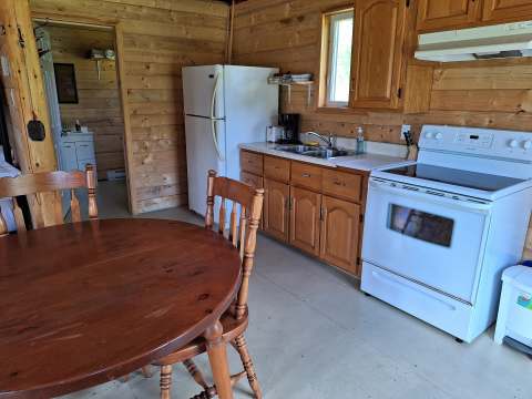 The equipped kitchen and wooden dining table of Chalet Matalik.