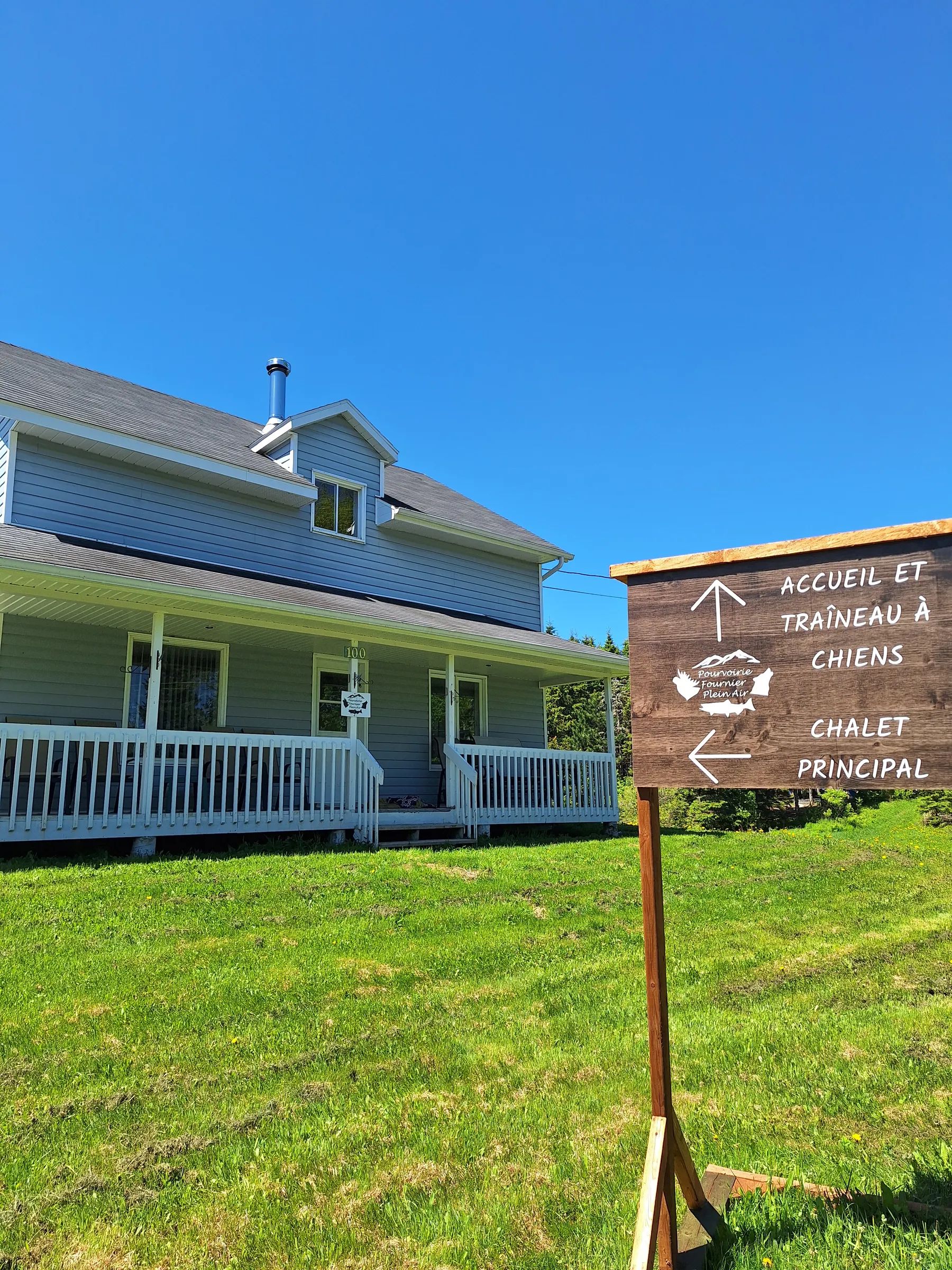 The main cottage with its gallery, located near the outfitter's signage.