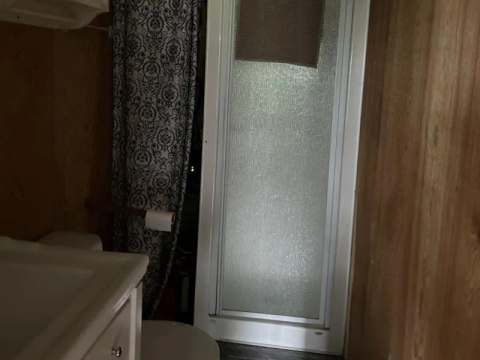 Vue de la salle de bain fonctionnelle avec douche et lavabo à l'intérieur du chalet.