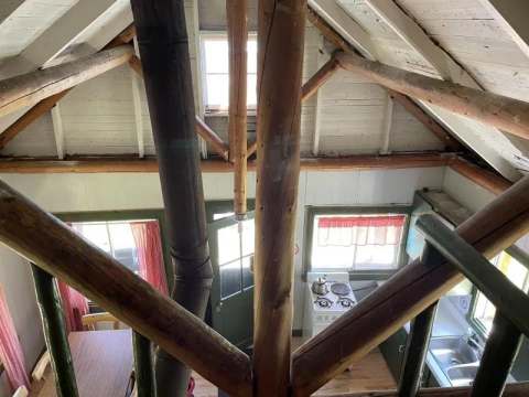 High-angle view of the cabin's ground floor, featuring its wooden structure and functional kitchen.
