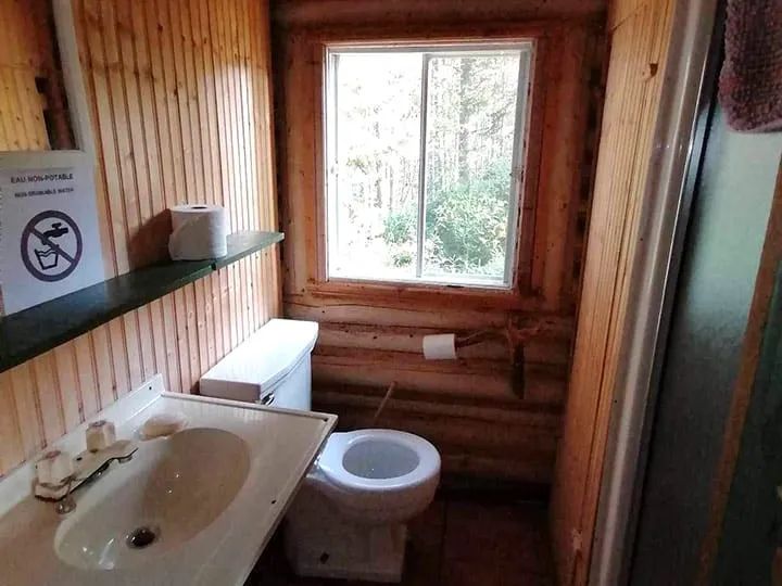 La salle de bain du chalet dispose d'un lavabo et d'une toilette fonctionnelle.