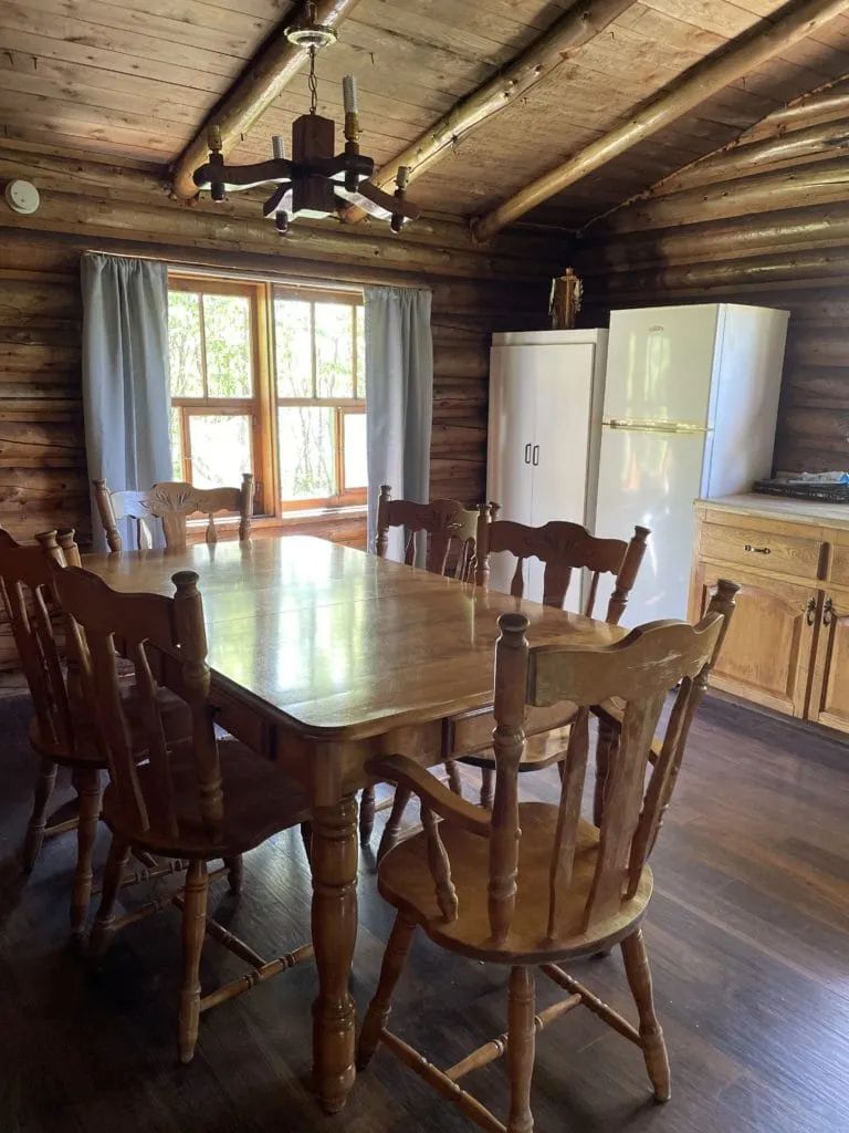 La salle à manger en bois rond avec sa grande table accueillante.