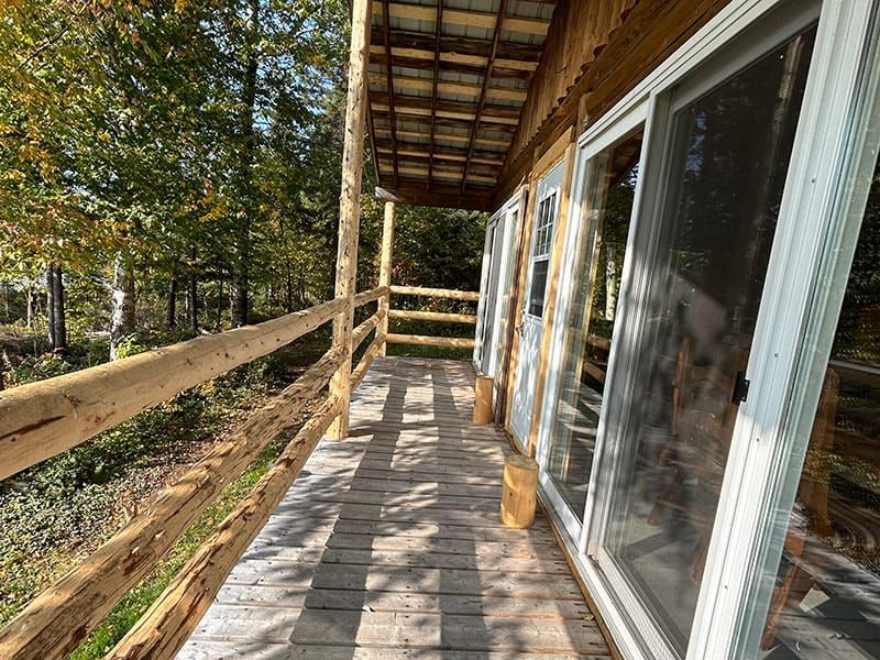 La galerie en bois du chalet offre un accès direct aux portes-fenêtres.