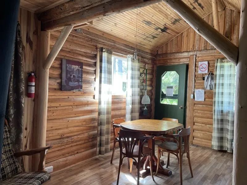 L'espace repas du chalet est aménagé avec une table en bois et ses chaises dans une ambiance rustique.