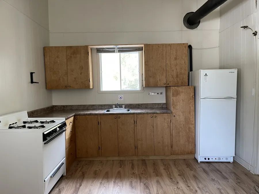 The functional kitchen of Chalet Alain is equipped with a stove, a refrigerator, and a sink.