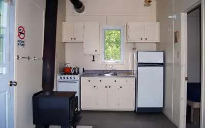 La cuisine fonctionnelle du chalet Éliane comprend une cuisinière, un réfrigérateur et un poêle à bois.