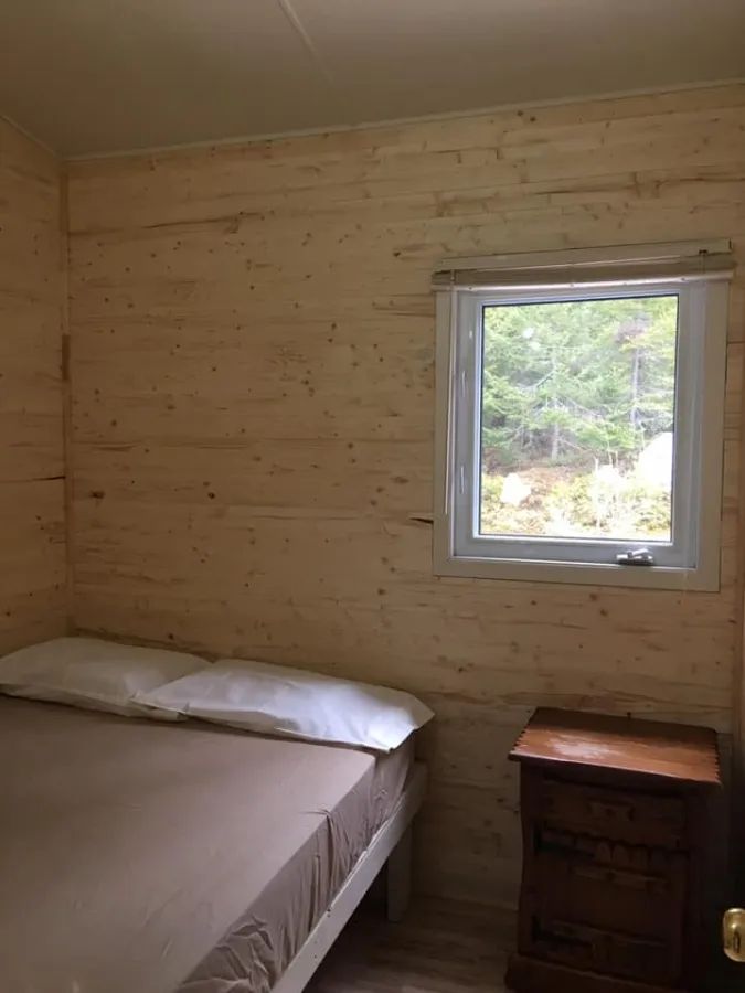 Une chambre lumineuse avec un lit confortable et une fenêtre donnant sur la forêt.