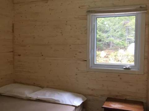 Une chambre lumineuse avec un lit confortable et une fenêtre donnant sur la forêt.
