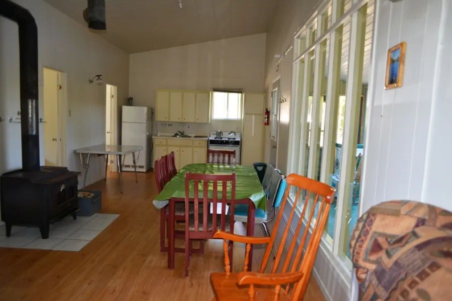 L'aire ouverte du chalet comprend une cuisine équipée, une table à manger et un poêle à bois.