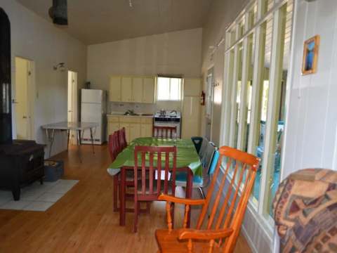 L'aire ouverte du chalet comprend une cuisine équipée, une table à manger et un poêle à bois.