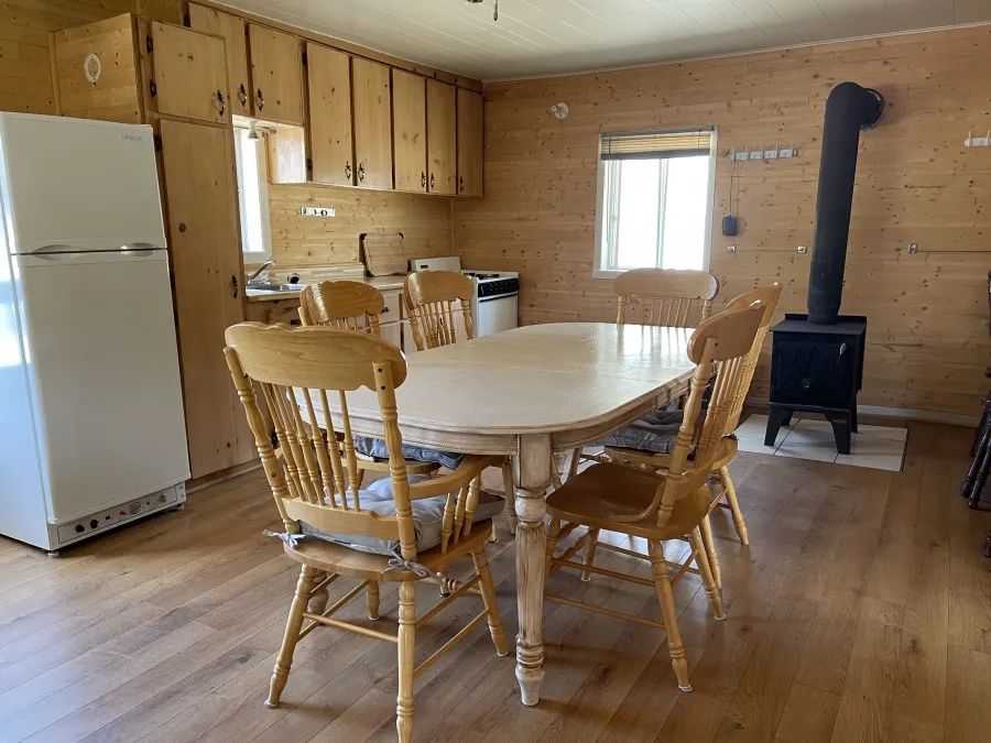 The open kitchen and dining area of the Samuel cottage with a wood stove.