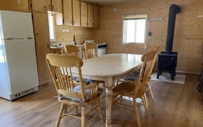 The kitchen and dining area of the Samuel chalet are equipped with a wood stove and a refrigerator.