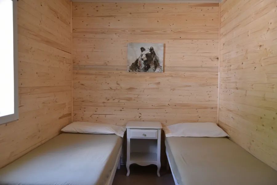 This bedroom in Chalet Samuel features two single beds separated by a nightstand.