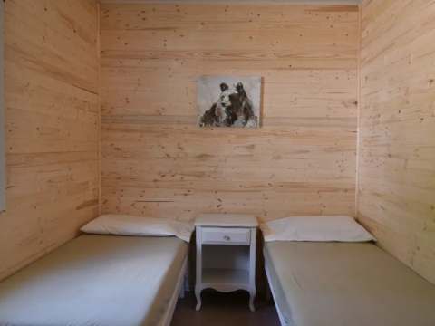 This bedroom in Chalet Samuel features two single beds separated by a nightstand.