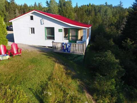 Exterior view of the Samuel cottage with its porch and chairs set up on the lawn.