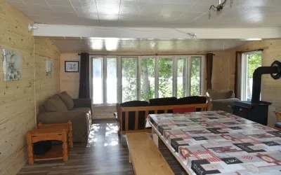 The interior of the Thérèse cabin features an open-plan area with a lounge corner and a dining table.