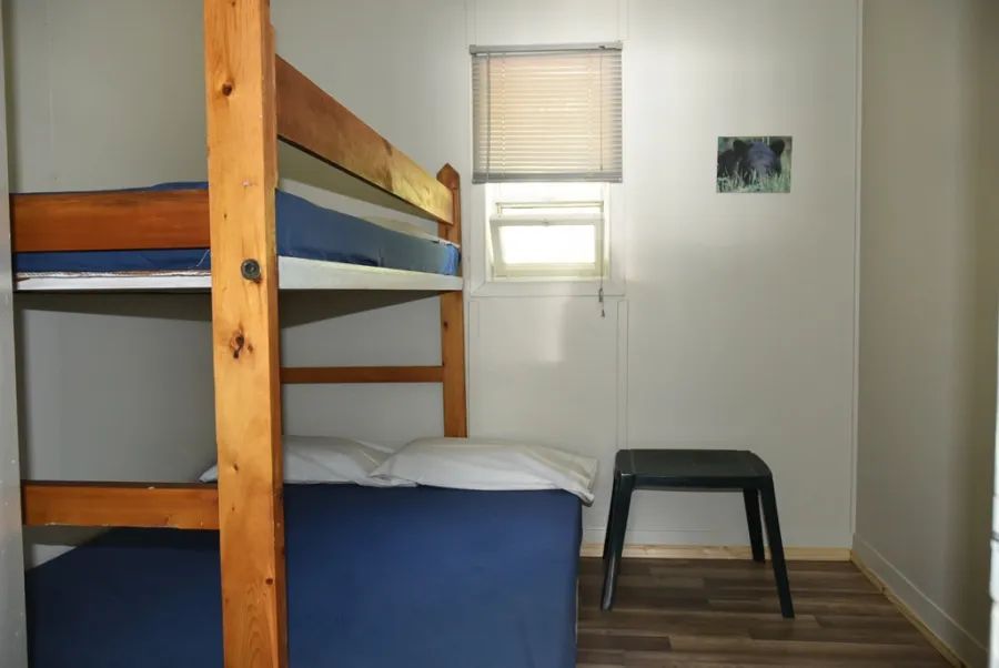 A bedroom in Chalet Thérèse featuring a wooden bunk bed and a small side table.