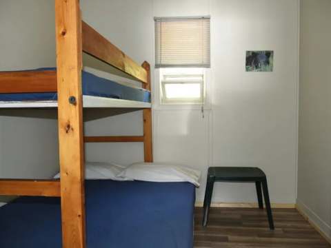 A bedroom in Chalet Thérèse featuring a wooden bunk bed and a small side table.