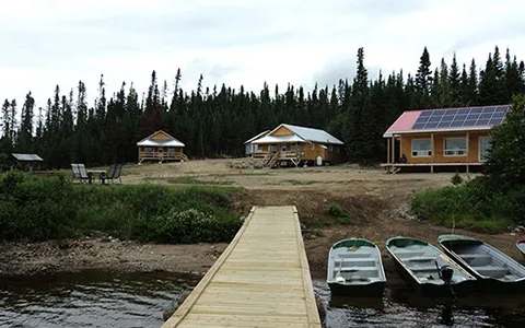 Overview of the outfitter's cabins and the dock with boats along the lake.