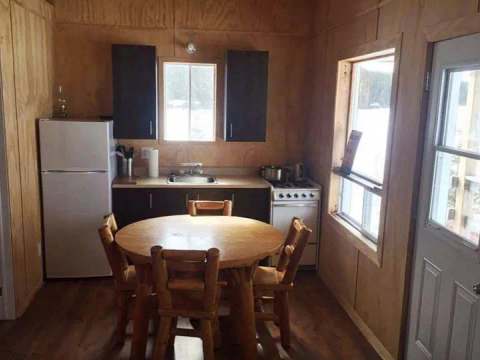 The equipped kitchen features a dining table and a view of the outdoors.