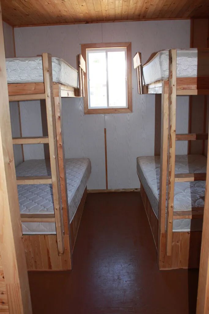Cette chambre du chalet 12 est équipée de deux lits superposés en bois.
