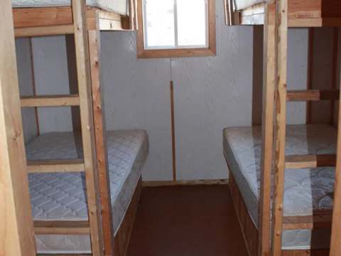 Cette chambre du chalet 12 est équipée de deux lits superposés en bois.
