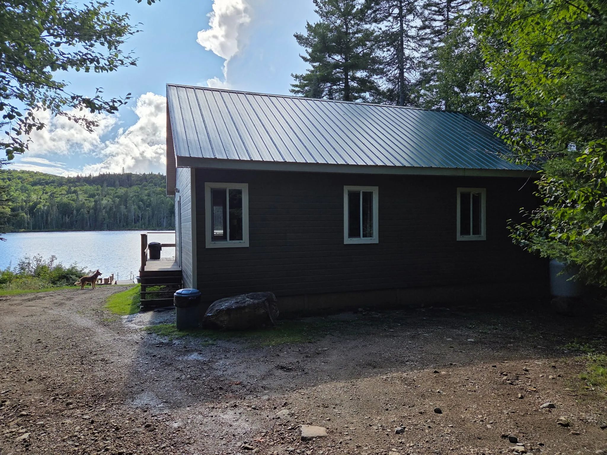 Vue latérale du chalet 4 situé au bord de l'eau avec une petite terrasse extérieure.