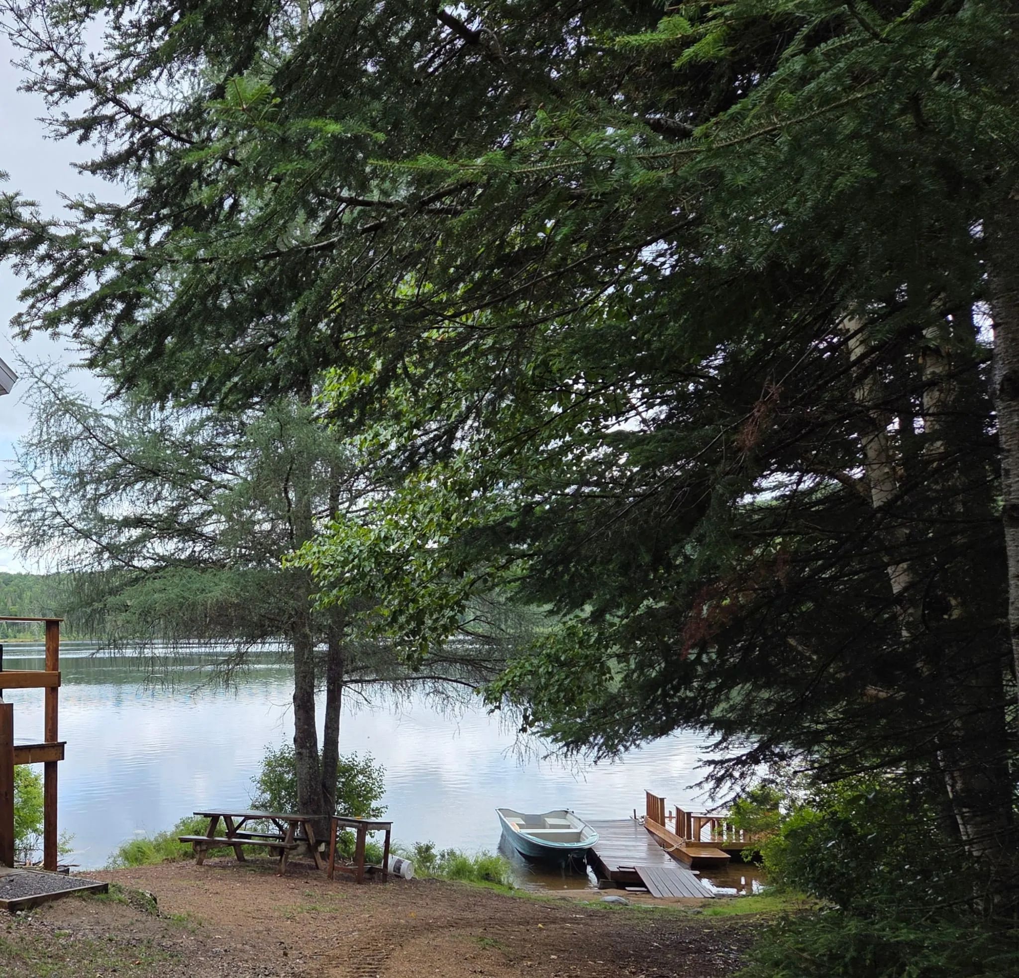 Vue sur le lac depuis le site du chalet 6 avec table de pique-nique et quai privé.