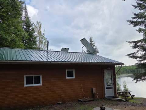 Le chalet 8 est situé en bordure de lac et possède un toit métallique avec des panneaux solaires.