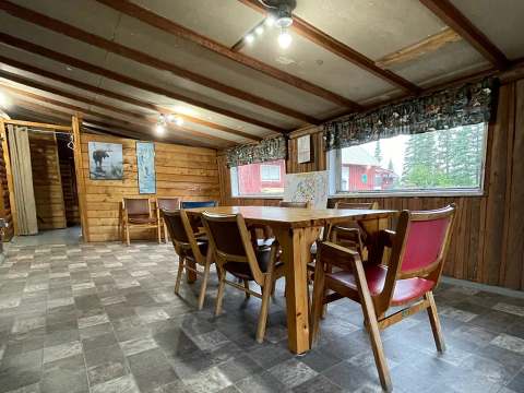 La salle à manger du chalet dispose d'une table en bois avec plusieurs chaises pour vos repas.
