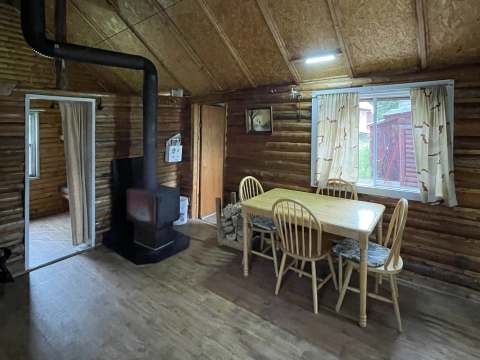 View of the dining area with wood stove inside the cabin.