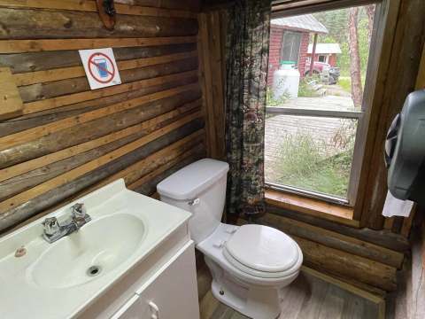 View of the functional bathroom with toilet and sink inside the cabin.