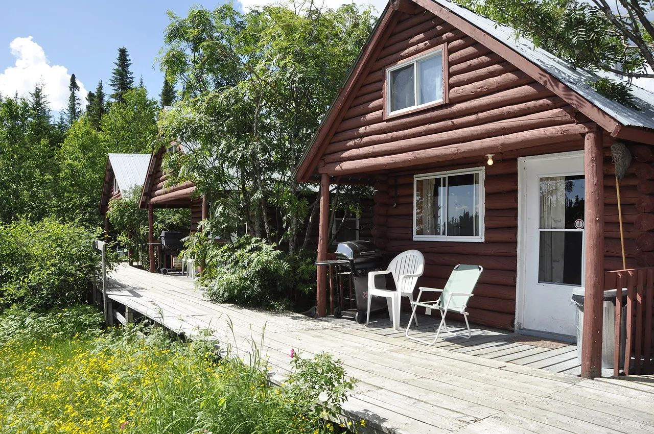 Side view of the log cabins with their outdoor terrace and barbecues.
