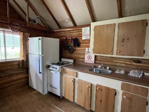 The equipped kitchen of chalet 2 includes a refrigerator, a stove, and a sink.