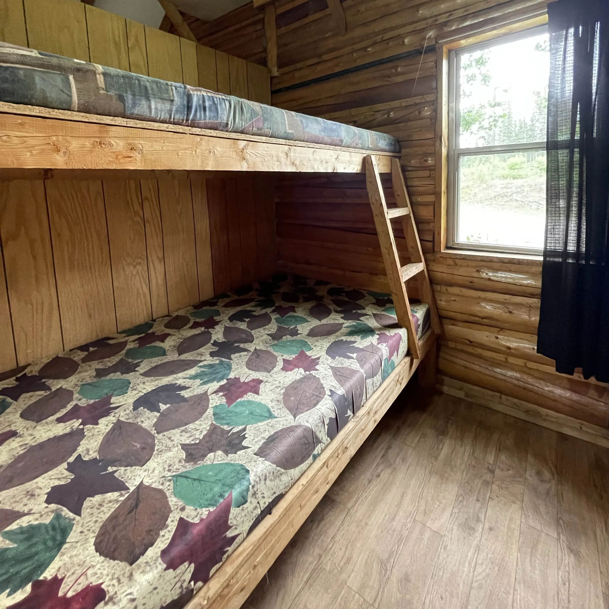 A wooden bunk bed is set up in the cabin to maximize sleeping space.