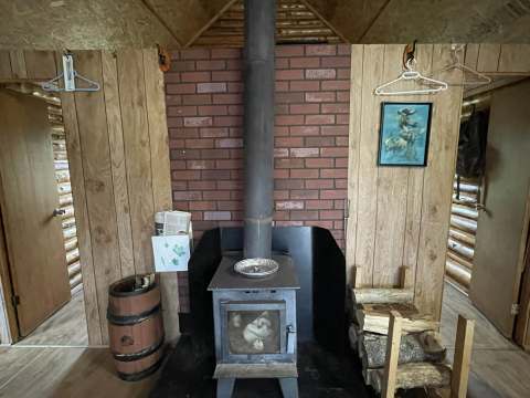 The cabin living area is equipped with a wood stove for your comfort.