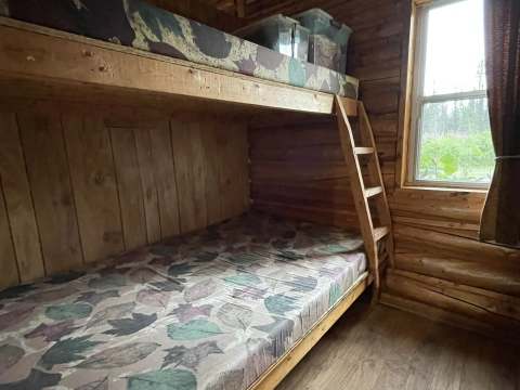 Chalet 3 features wooden bunk beds with a view of the forest.