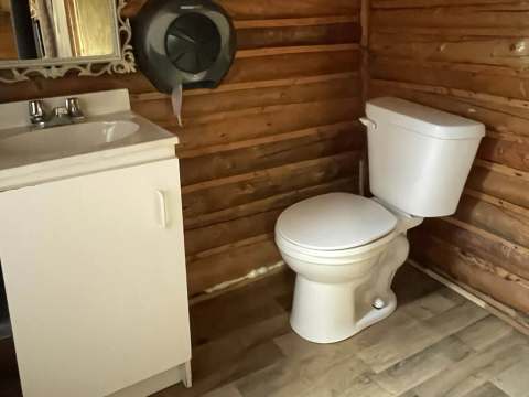 View of the functional bathroom with toilet and sink in the cabin.