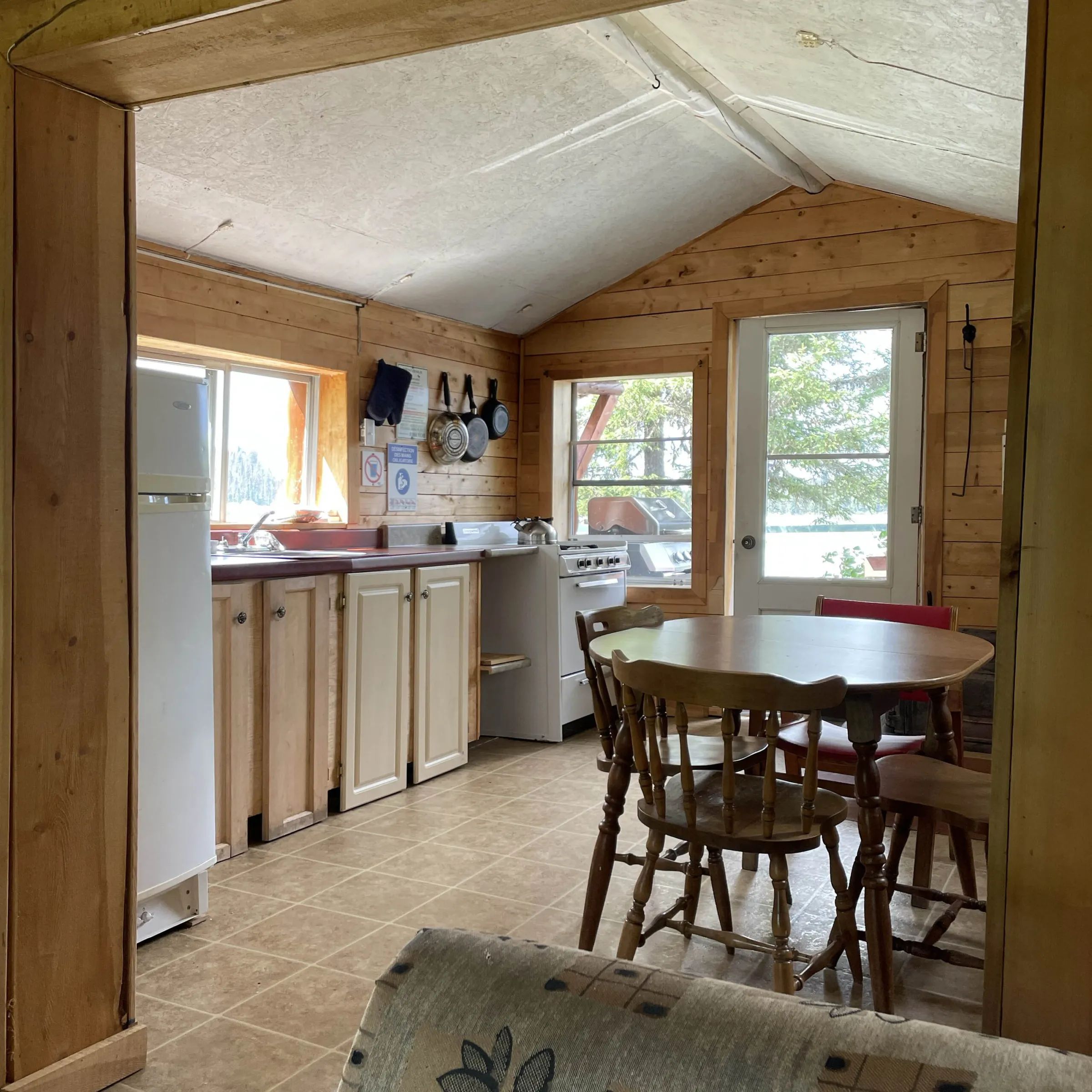 The cabin kitchen and dining area are equipped with a stove and a wooden table.