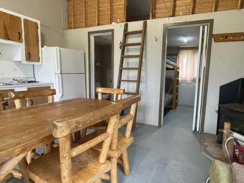 View of the rustic kitchen and dining area with access to the bedrooms in cabin 7.