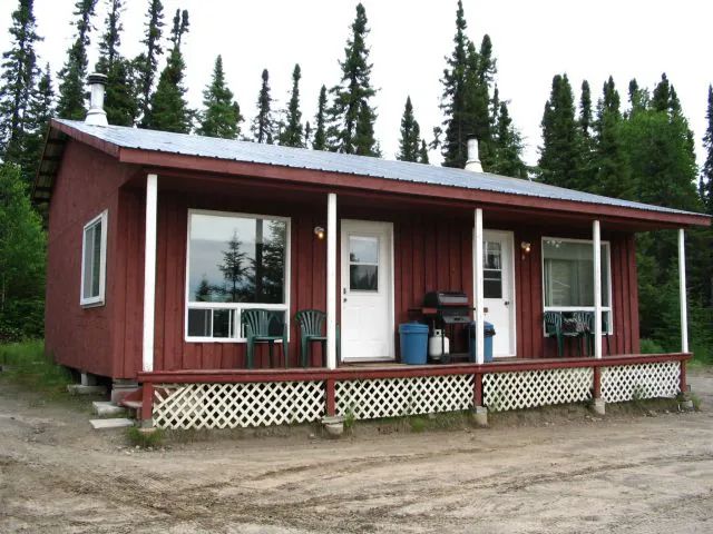 Exterior view of the cabin with a porch and chairs to enjoy the outdoors.