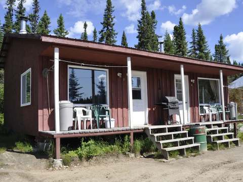 Vue extérieure du chalet 8 avec sa galerie et son mobilier de plein air.