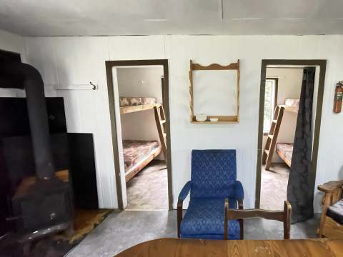 La zone principale du chalet Baribal comprend un poêle à bois, un coin salon et deux chambres à coucher.