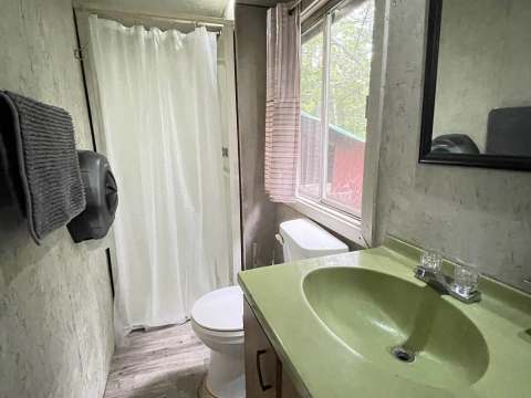 Vue de la salle de bain fonctionnelle avec douche et lavabo dans le chalet Baribal.